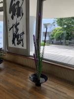 「緑樹」の脇に立つ生け花作品